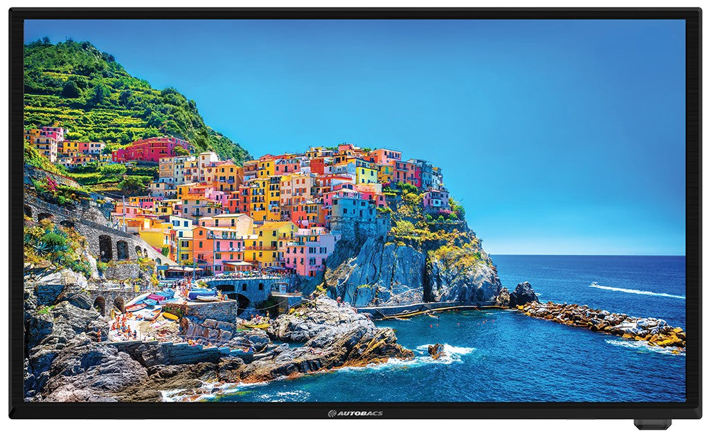 TV screen displaying a scenic view of colorful coastal town with blue sea and clear sky.